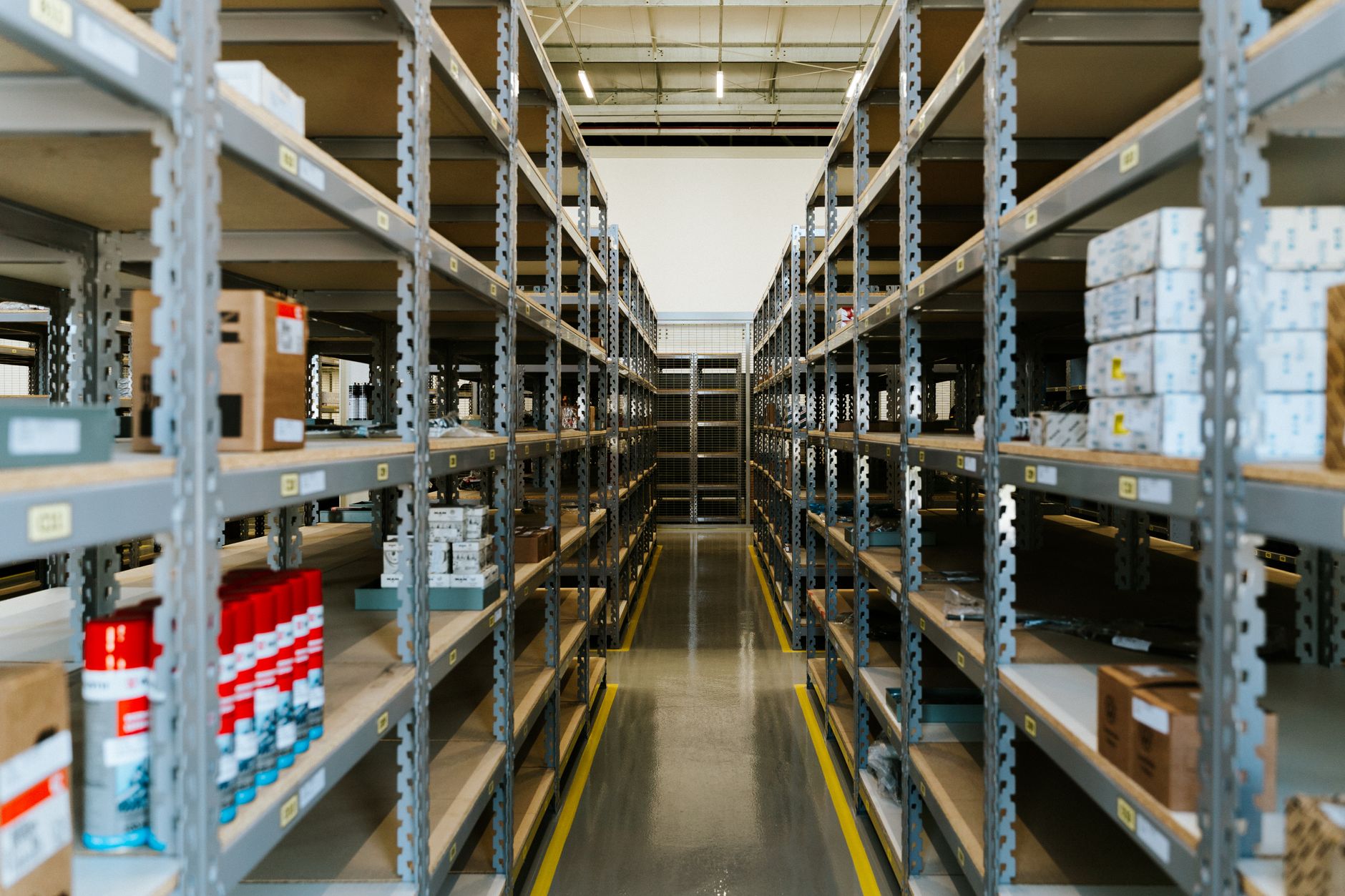 Centro de distribuição organizado, com prateleiras metálicas e mercadoria estocada