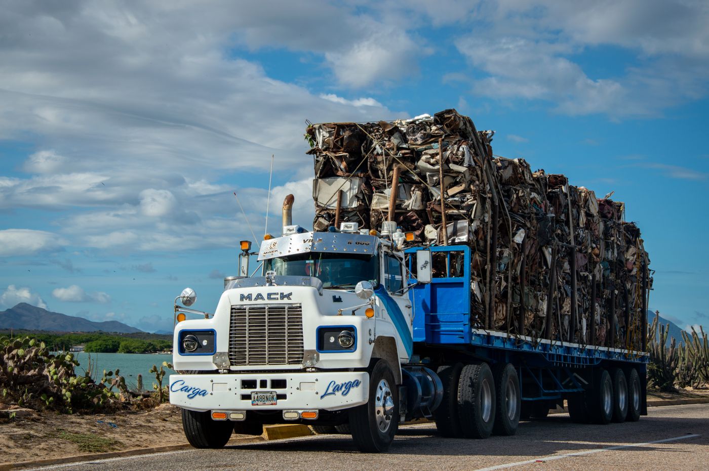 Caminhão carregado com fardos de material reciclável seguindo para a rota de coleta